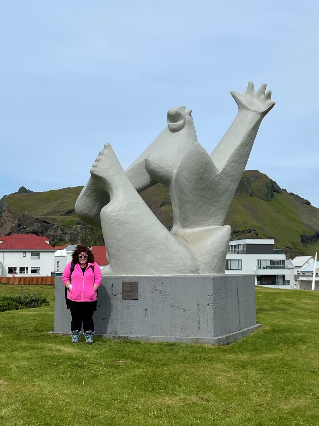 Woman wearing a bright pink jumper standing in front of a statue
