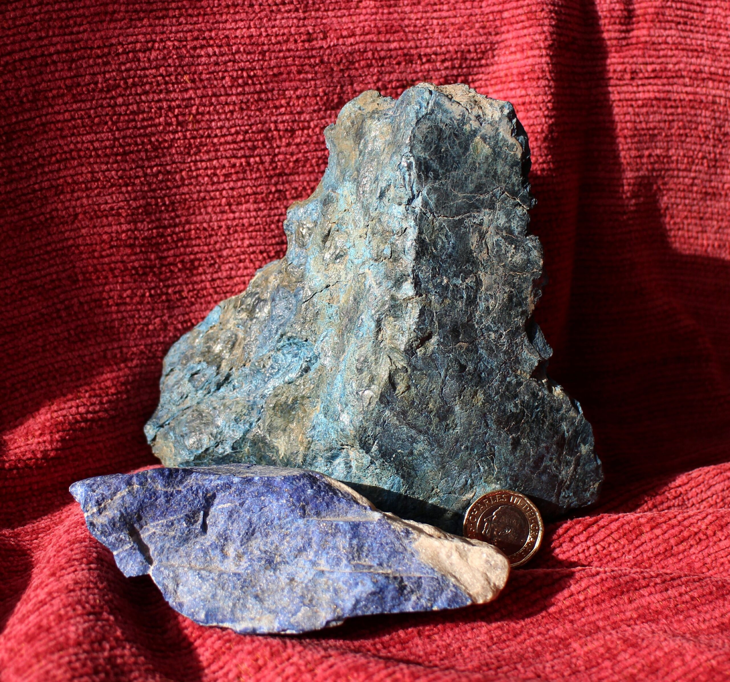 Two striking blue minerals displayed on a red blanket