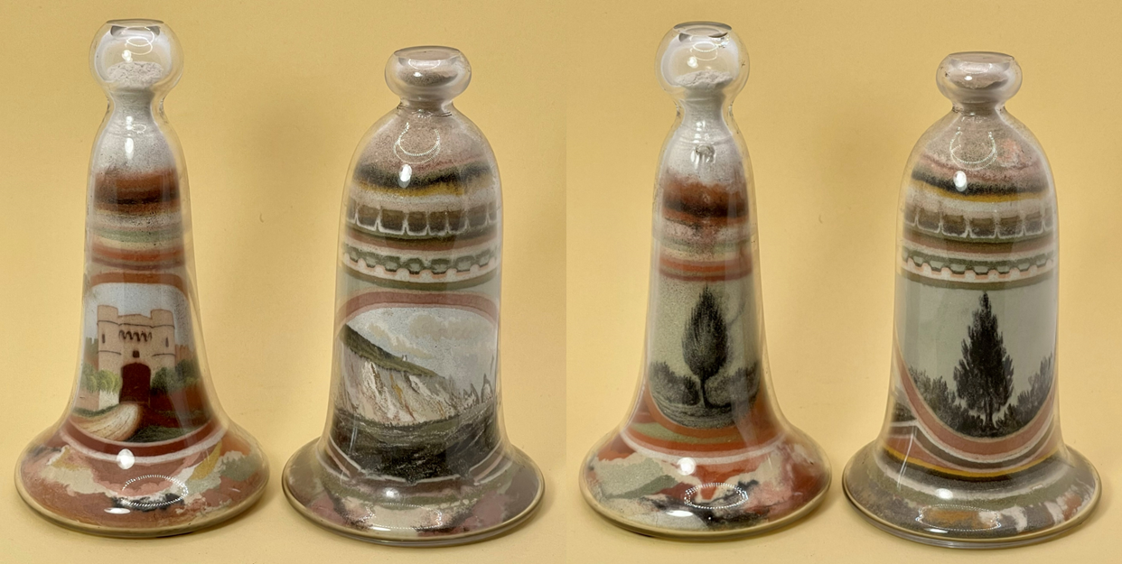 Glass bells filled with coloured sand depicting coastal locations like a picture